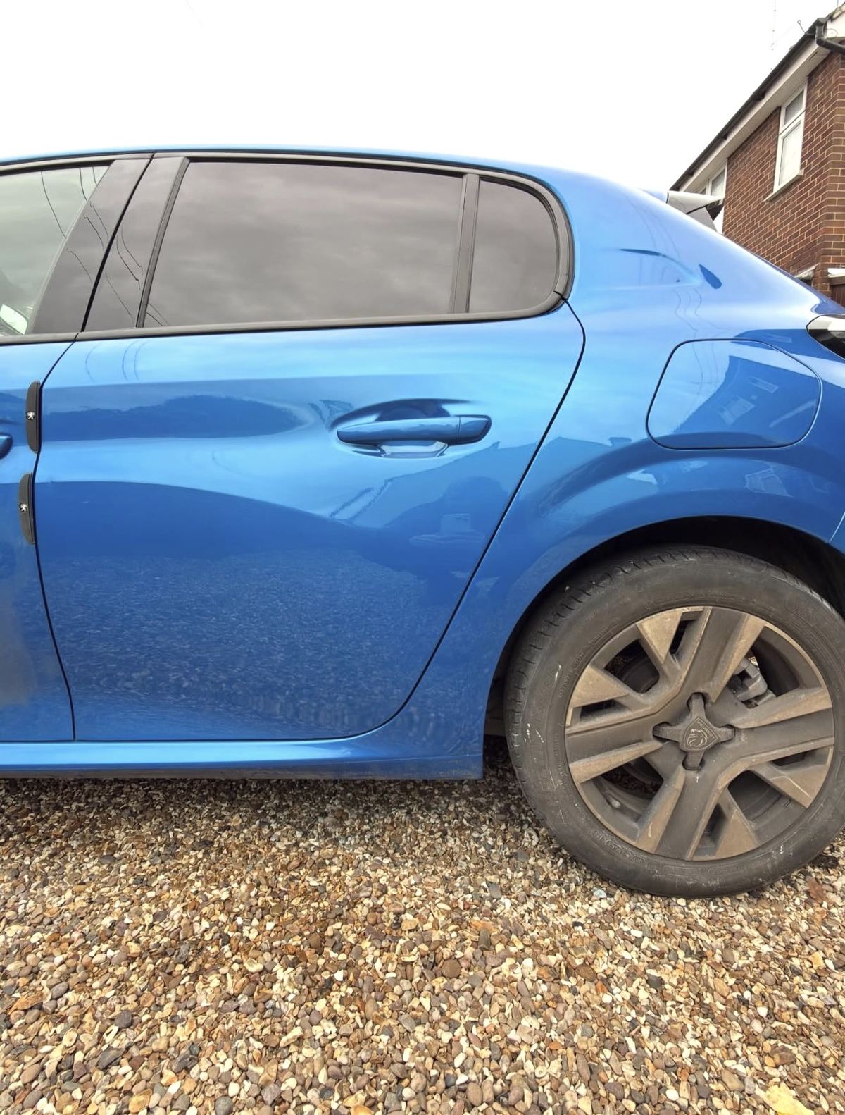 Peugeot door scratch and scuff after repair — factory blue colour-matched, invisible finish
